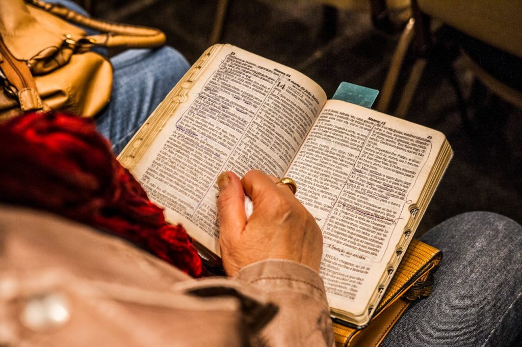 A person reading a Bible indoors, symbolizing spirituality and devotion.